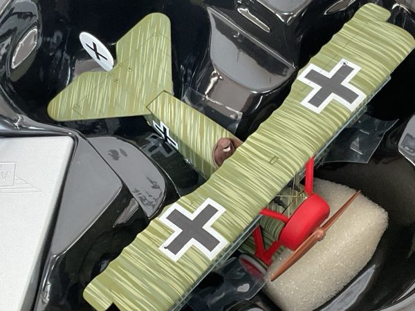 Close-up of Fokker Dr.1 Triplane die-cast model in packaging with green and red detailing